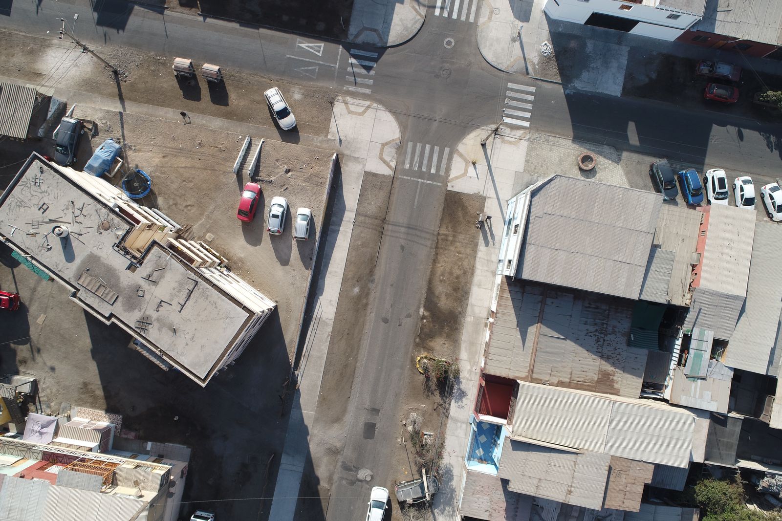 Ortofoto de dron de una intersección urbana con vehículos y cruces peatonales